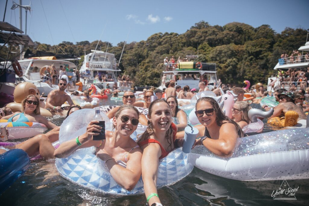 A group of people enjoying a catamaran party in Sydney Harbour.