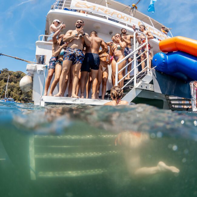 A group of people in swimwear gather on the back of a catamaran for an unforgettable Sydney boat party hire.