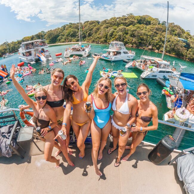 A group of women in garments posing for a picture on a boat.