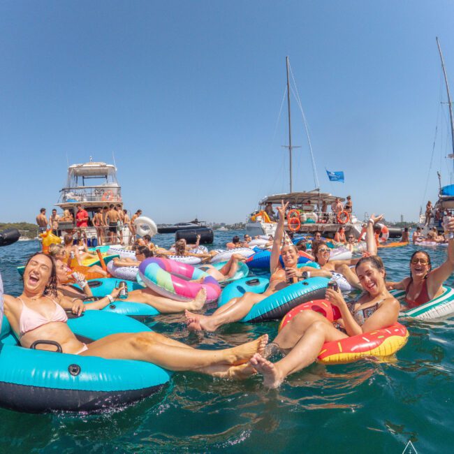 A group of people floating on inner tubes in water.