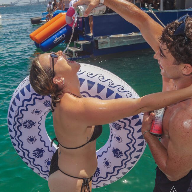 A man and woman in a swimsuit pouring water into a tube.